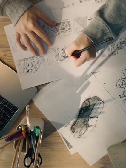 Plano vertical de un artista dibujando en su escritorio